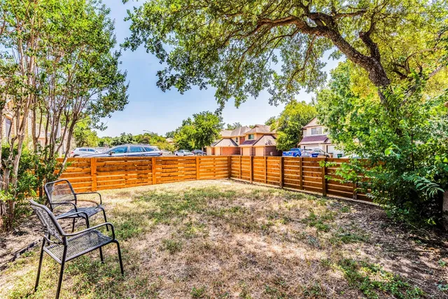 a view of yard with tree and wooden fence