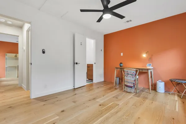 a view of empty room with wooden floor
