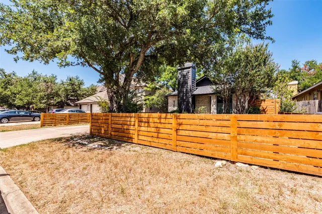 a view of a yard with wooden fence