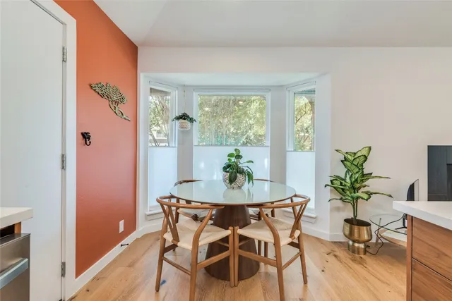 a dining room with furniture potted plants and wooden floor
