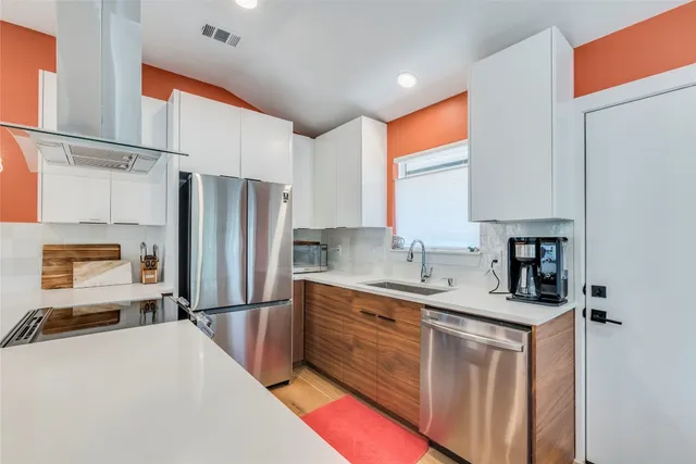 a kitchen with stainless steel appliances a refrigerator sink and cabinets