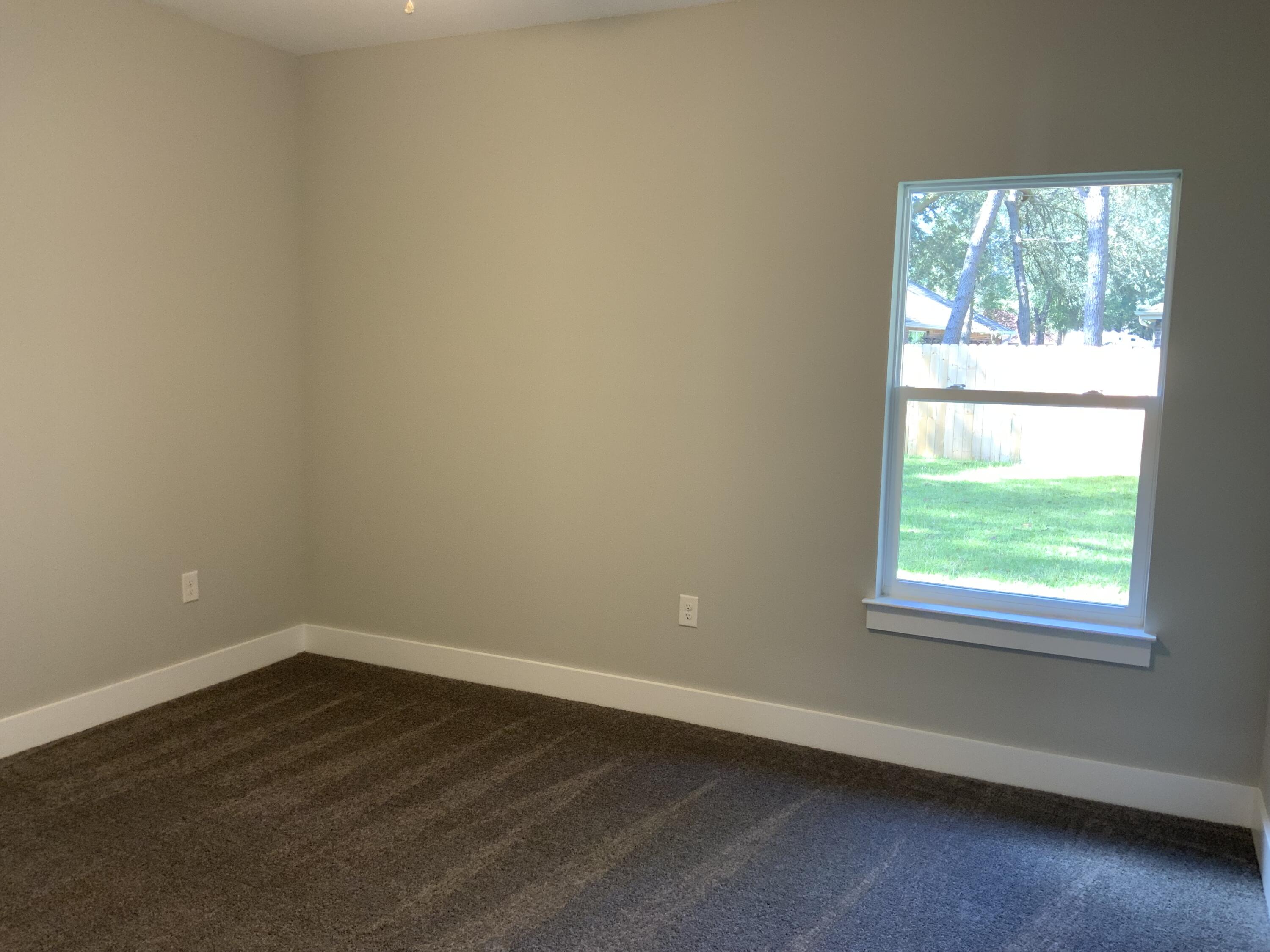 2800 Ram Lane Crestview, FL 32539 - Photo 11 of 20 an empty room with wooden floor and windows