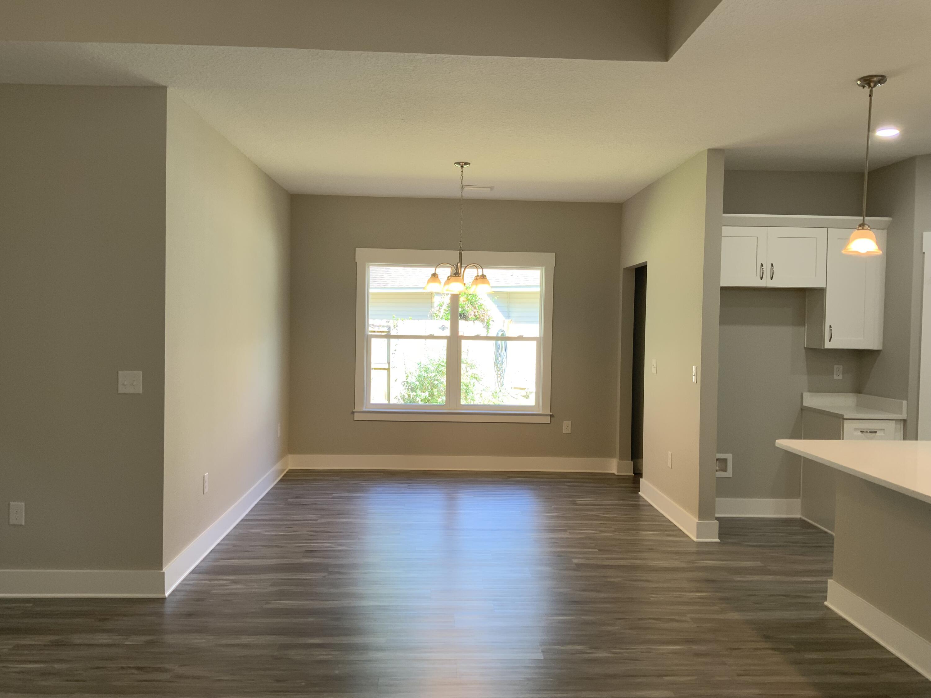 2800 Ram Lane Crestview, FL 32539 - Photo 4 of 20 a view of an empty room with wooden floor and a window