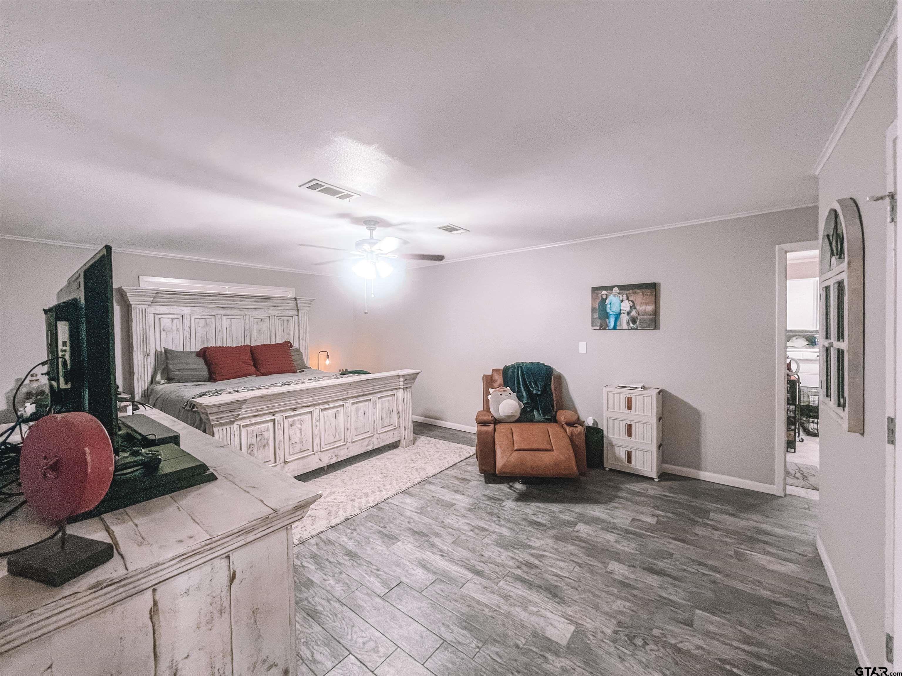 648 Daingerfield Street Pittsburg, TX 75686 - Photo 13 of 27 a bedroom with furniture and wooden floor