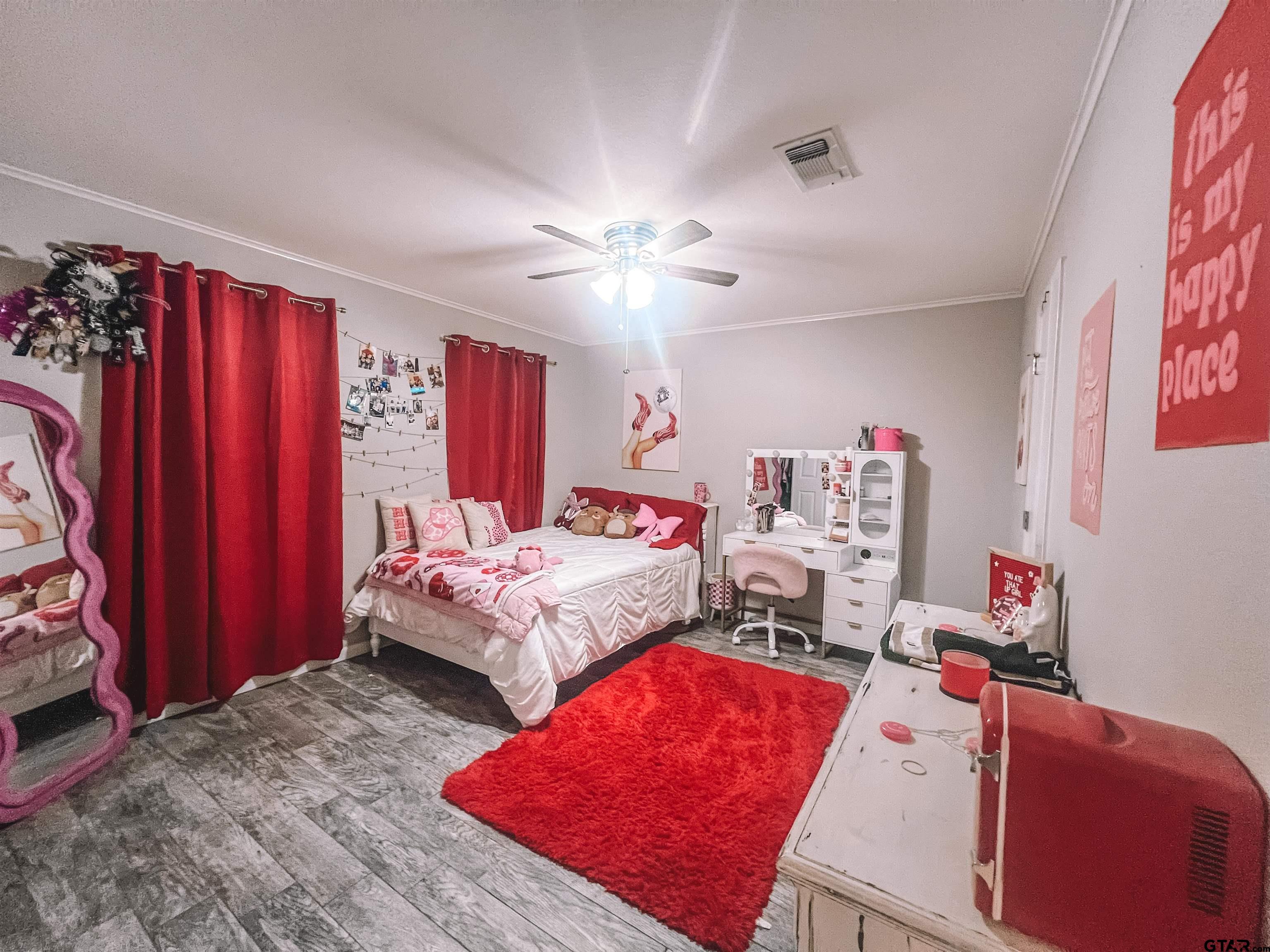 648 Daingerfield Street Pittsburg, TX 75686 - Photo 16 of 27 a bedroom with a bed and a chandelier