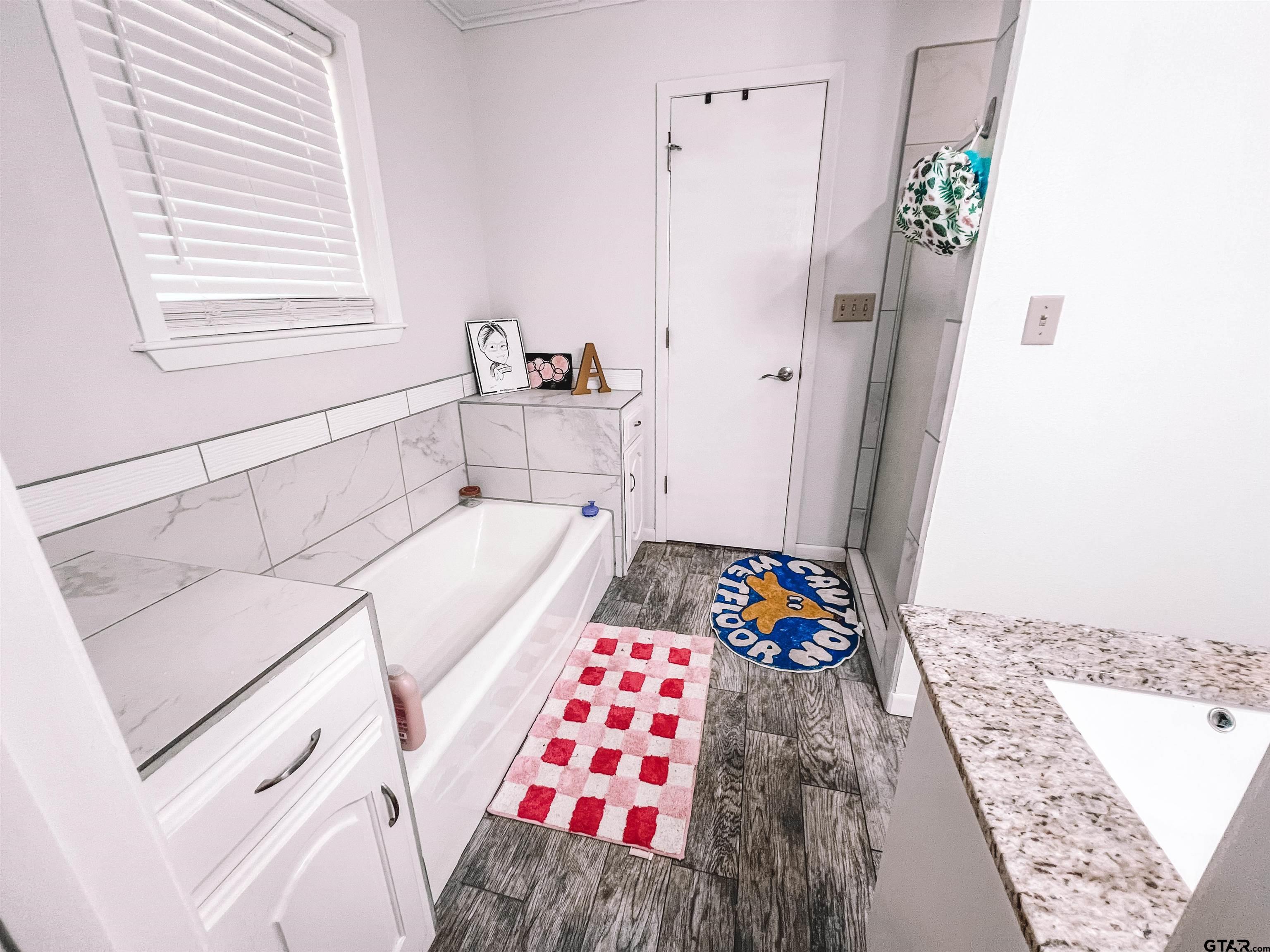 648 Daingerfield Street Pittsburg, TX 75686 - Photo 19 of 27 a bath room with a bed and a rug