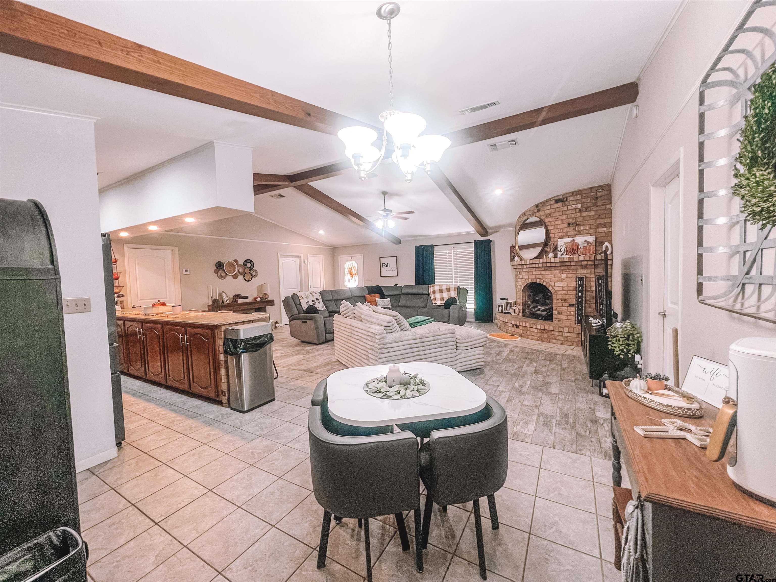 648 Daingerfield Street Pittsburg, TX 75686 - Photo 6 of 27 a open kitchen with stainless steel appliances kitchen island granite countertop a sink a stove a dining table and chairs with wooden floor