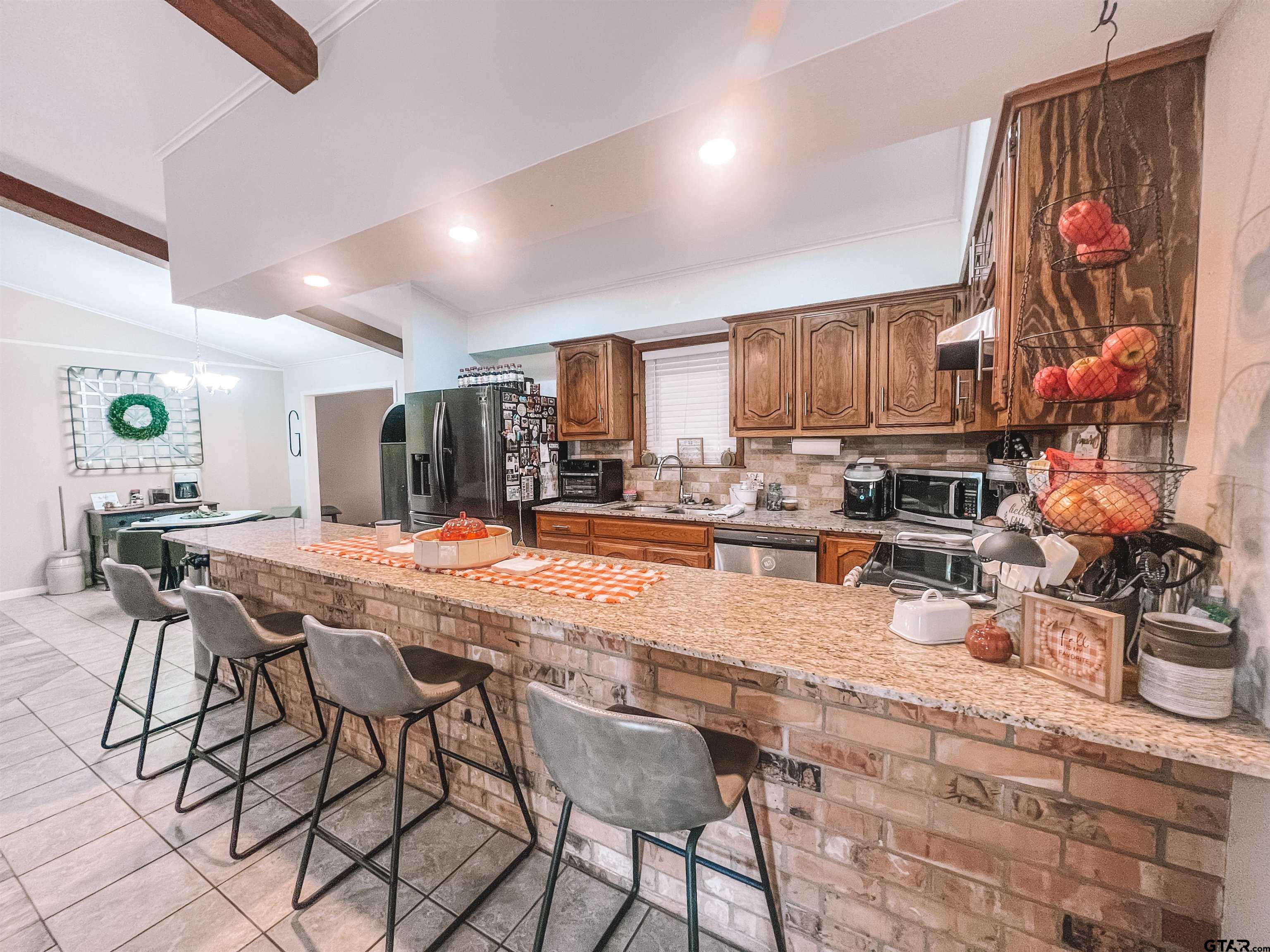 648 Daingerfield Street Pittsburg, TX 75686 - Photo 7 of 27 a kitchen with stainless steel appliances kitchen island granite countertop a table and chairs in it