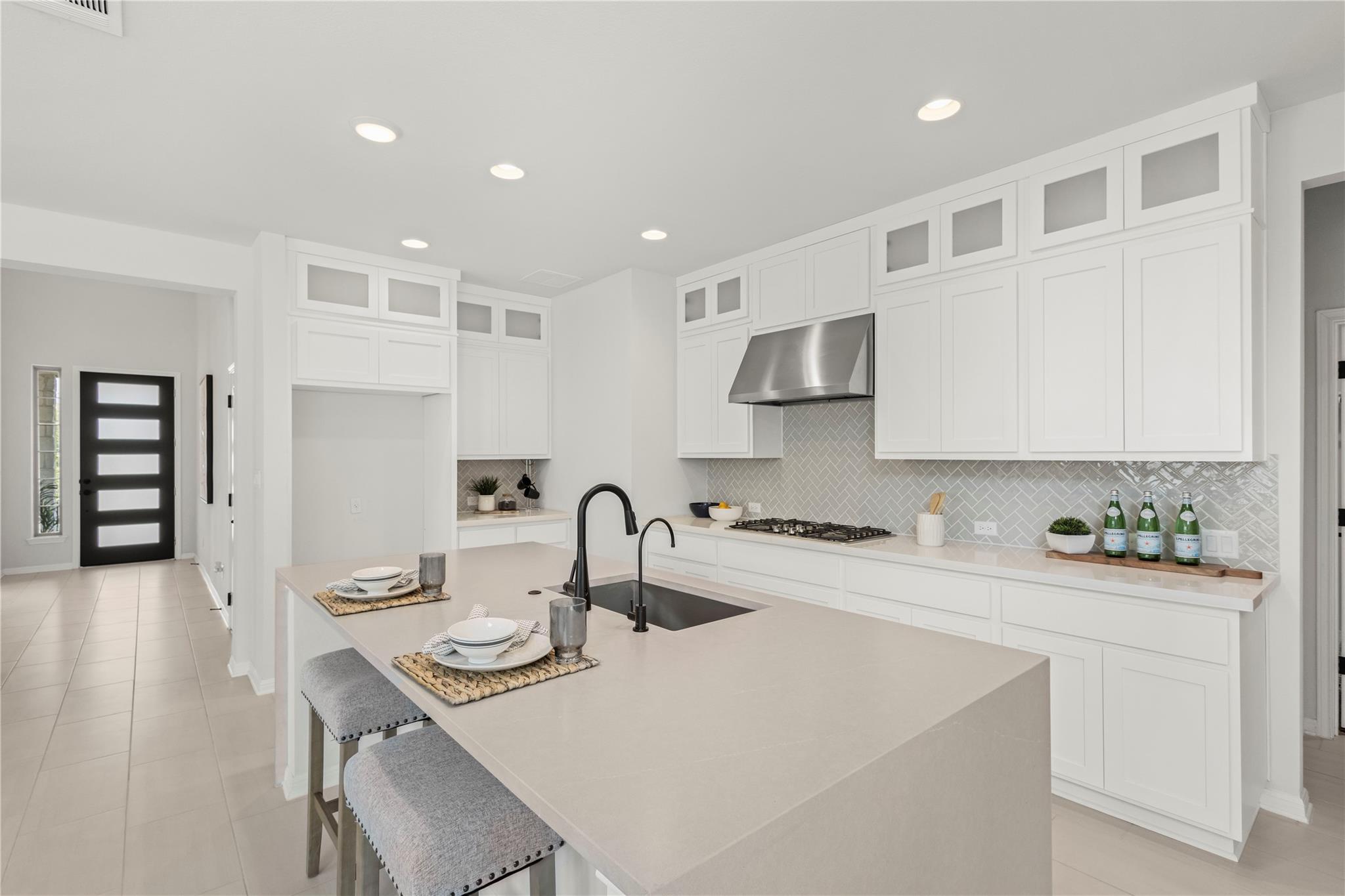 1128 Villa Rialto View Leander, TX 78641 - Photo 15 of 40 Kitchen featuring a kitchen breakfast bar, white cabinetry, glass insert cabinets, an island with sink, and recessed lighting