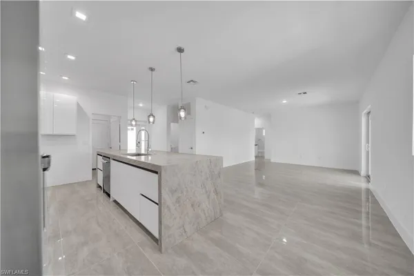 a large kitchen with kitchen island a sink stainless steel appliances and a counter top