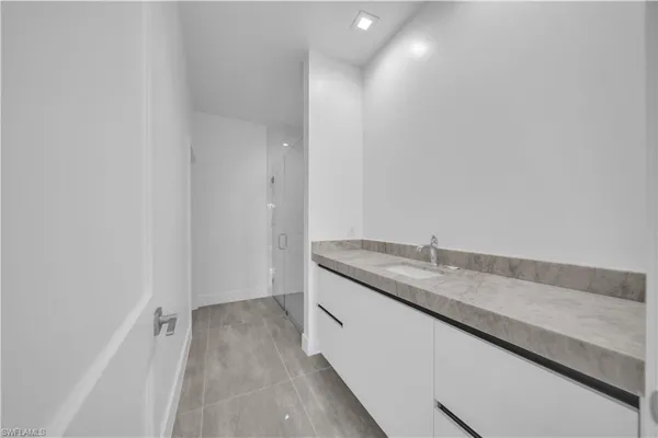 a bathroom with a granite countertop sink and a vanity