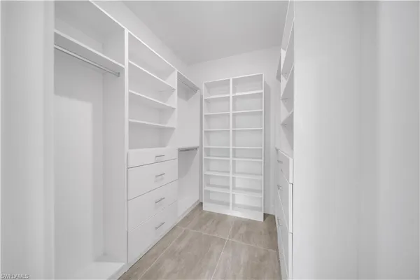 a view of walk in closet with empty racks