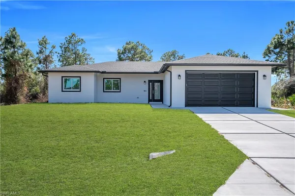 a view of a house with a yard and a garage