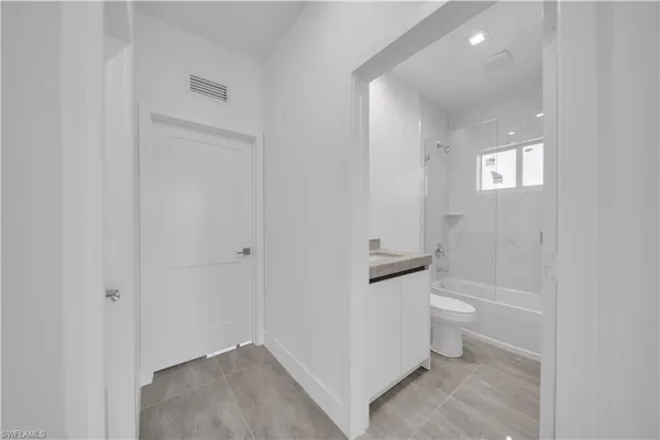 a bathroom with a granite countertop sink toilet and bathtub