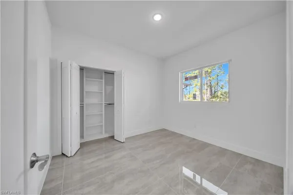 an empty room with a wooden floor and window