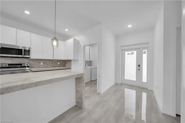 a large kitchen with stainless steel appliances granite countertop a refrigerator a stove and a sink