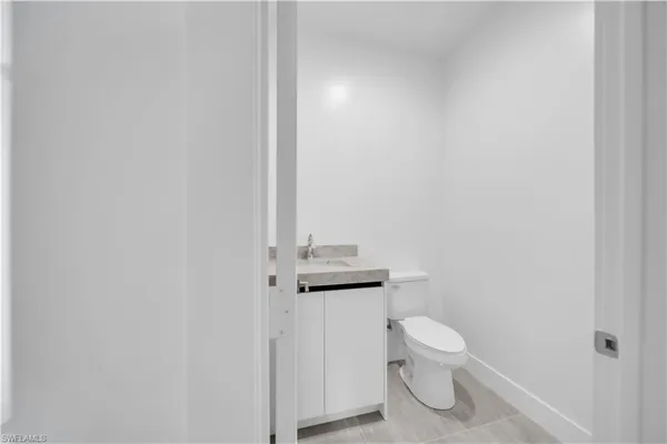 a bathroom with a granite countertop toilet and a sink