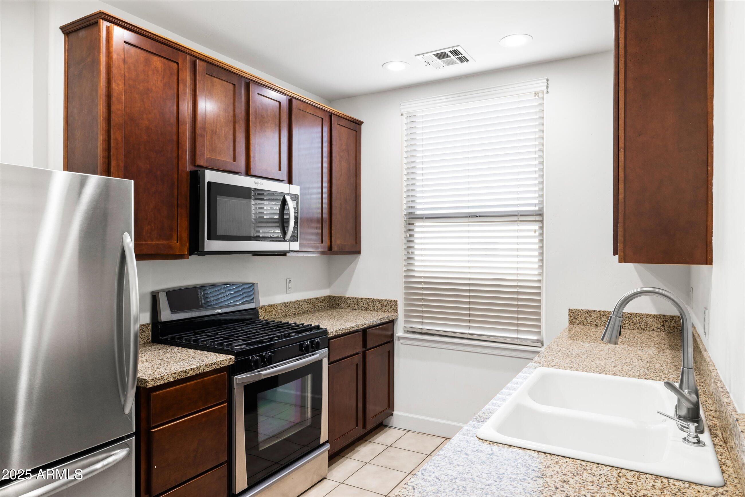 505 West 6th Street Tempe, AZ 85281 - Photo 13 of 32 a kitchen with stainless steel appliances granite countertop a sink stove and microwave