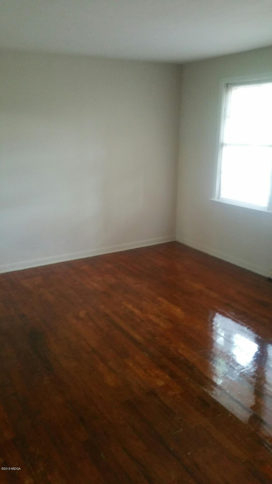 4843 Brookhaven Road Macon, GA 31206 - Photo 2 of 7 an empty room with wooden floor and windows in it