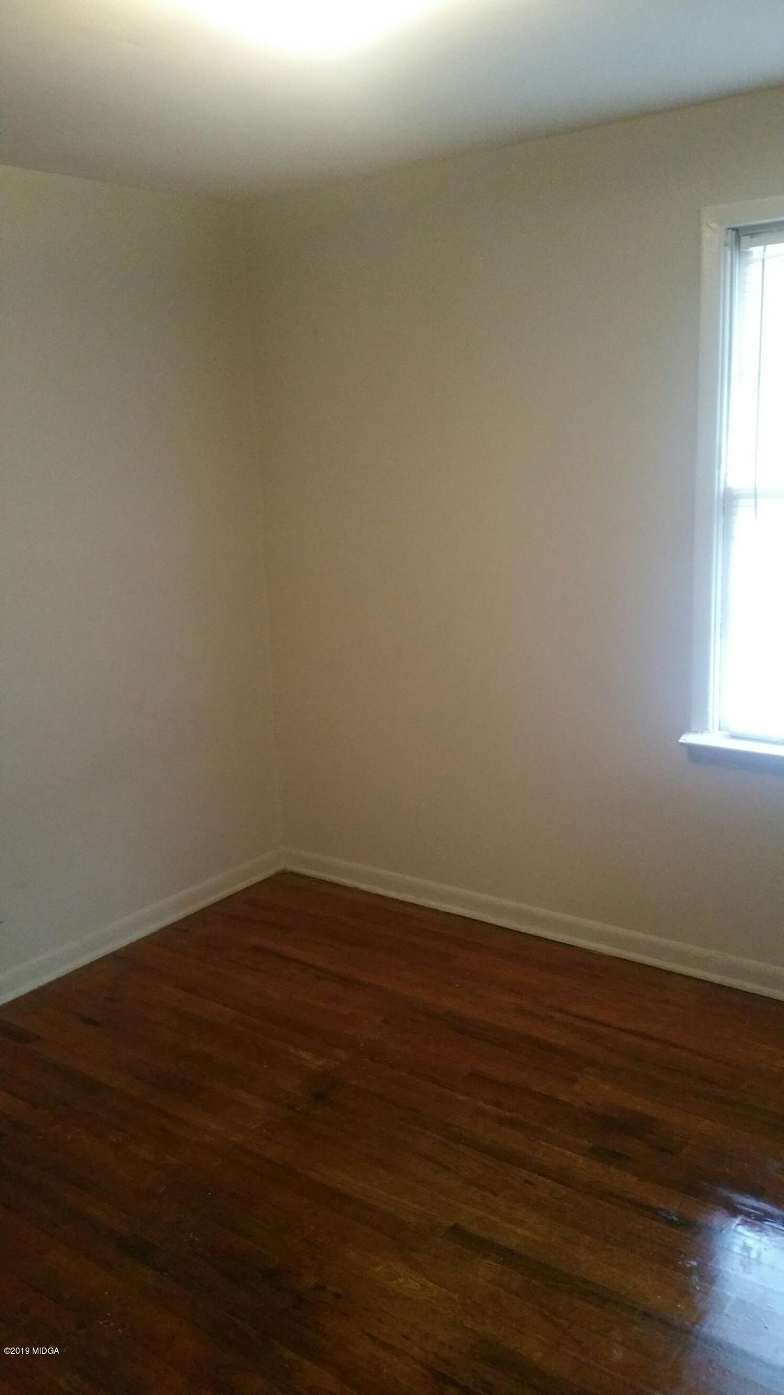 4843 Brookhaven Road Macon, GA 31206 - Photo 4 of 7 a view of an empty room with wooden floor and a window