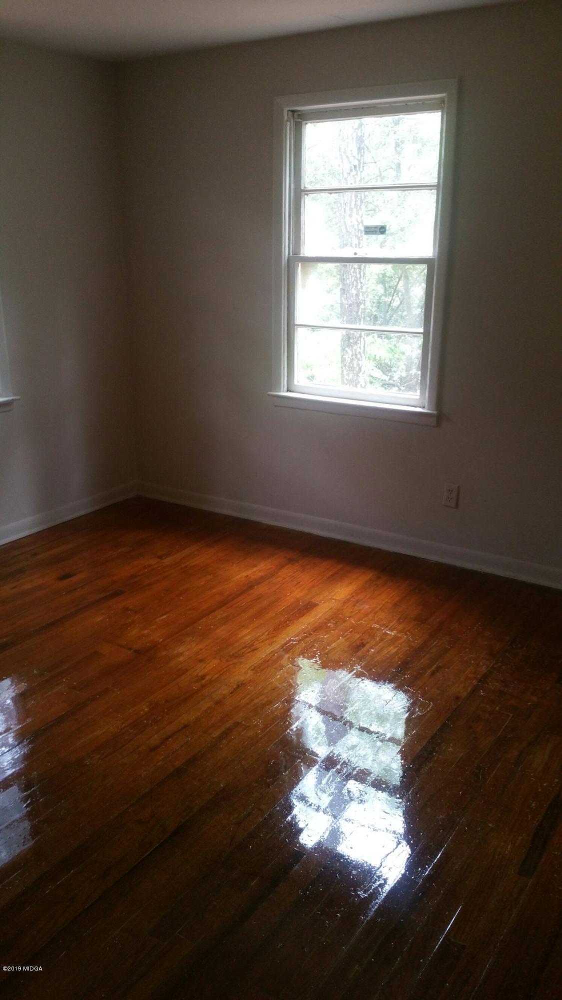 4843 Brookhaven Road Macon, GA 31206 - Photo 7 of 7 an empty room with wooden floor and windows