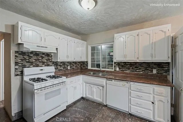 a kitchen with white cabinets and appliances