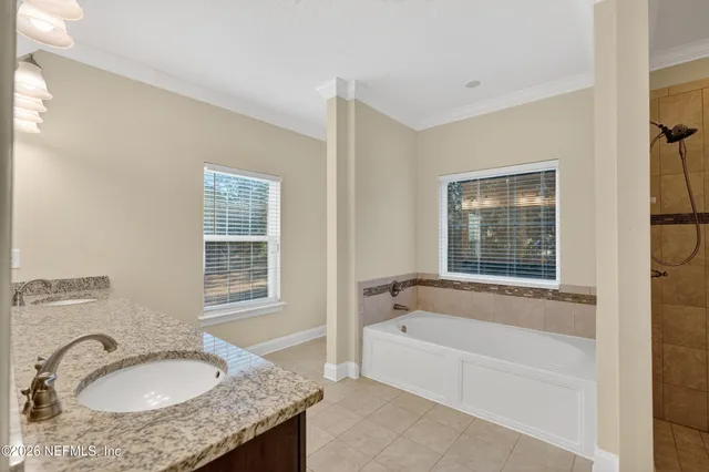 a bathroom with a granite countertop tub sink and mirror