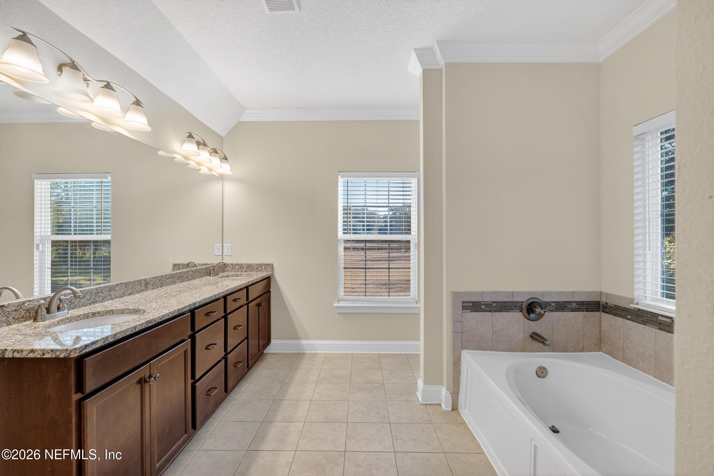13576 Dunn Creek Road Jacksonville, FL 32218 - Photo 16 of 54 a spacious bathroom with a granite countertop tub sink and mirror