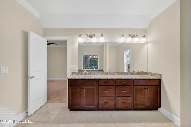 a spacious bathroom with a granite countertop sink and a mirror