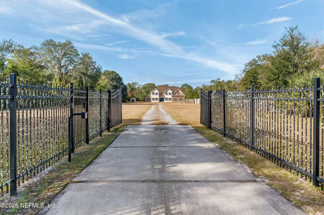 a view of a pathway with a wrought fence