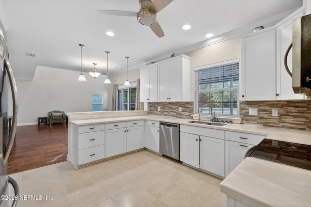 a large white kitchen with lots of counter space and a sink