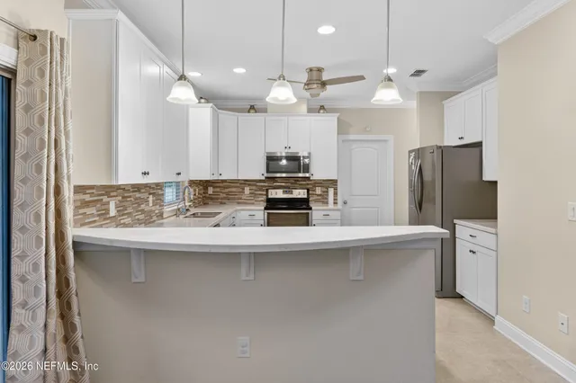 a kitchen with stainless steel appliances granite countertop a sink a stove a refrigerator and island with wooden floor