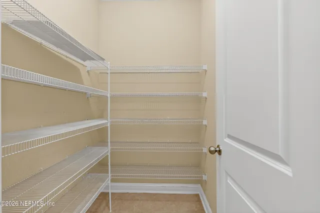 a view of walk in closet with empty racks