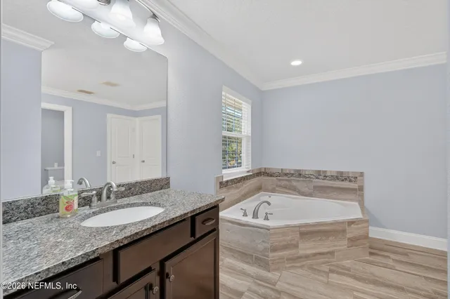 a bathroom with a granite countertop sink and a bathtub