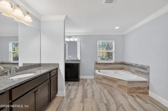 a spacious bathroom with a granite countertop tub sink and mirror
