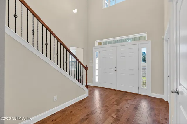 a view of a hallway with wooden floor and staircase