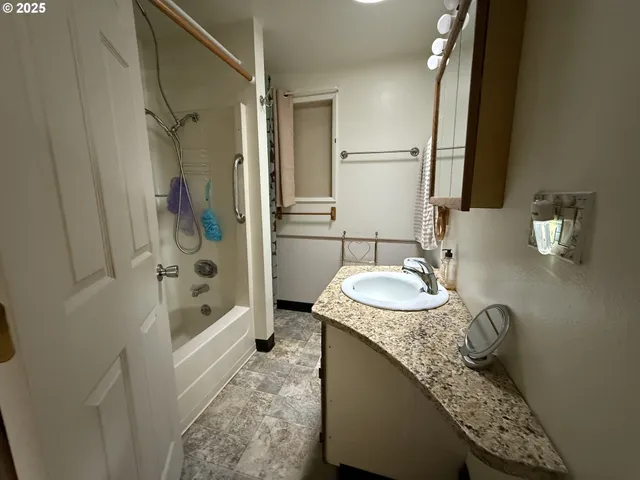 a bathroom with a granite countertop sink a toilet and shower