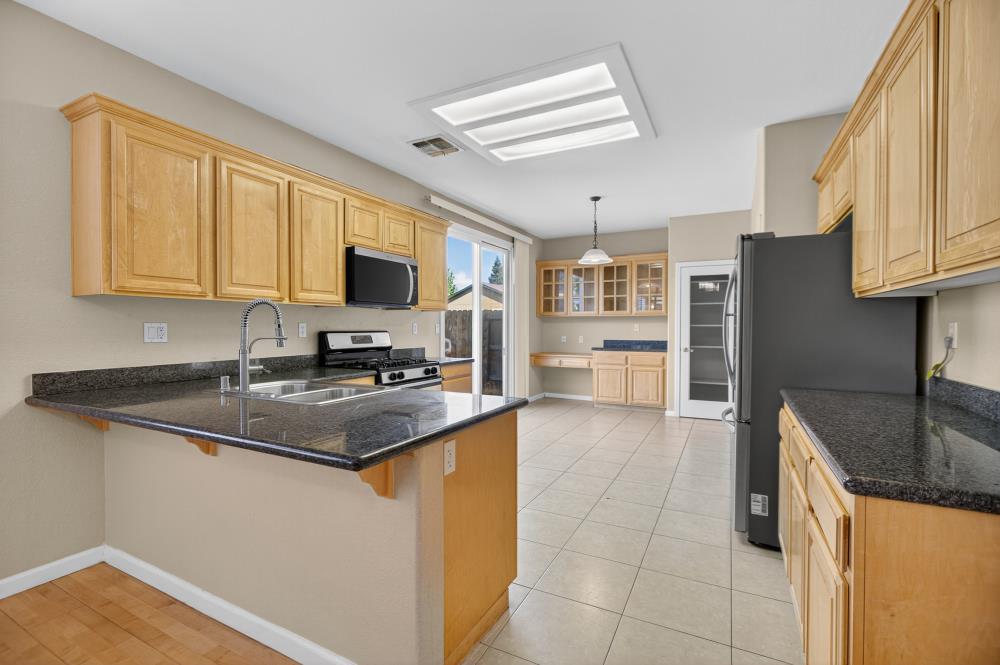 5817 Spring Flower Drive Elk Grove, CA 95757 - Photo 17 of 62 a kitchen with stainless steel appliances granite countertop a sink stove and refrigerator