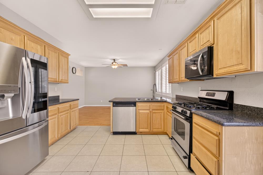 5817 Spring Flower Drive Elk Grove, CA 95757 - Photo 19 of 62 a kitchen with stainless steel appliances granite countertop a stove a sink and a refrigerator