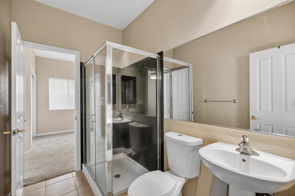 5817 Spring Flower Drive Elk Grove, CA 95757 - Photo 25 of 62 a bathroom with a toilet sink shower and mirror