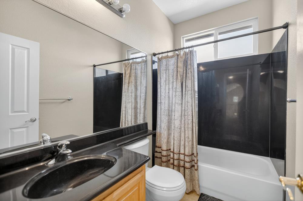 5817 Spring Flower Drive Elk Grove, CA 95757 - Photo 38 of 62 a bathroom with a sink a toilet a mirror and shower