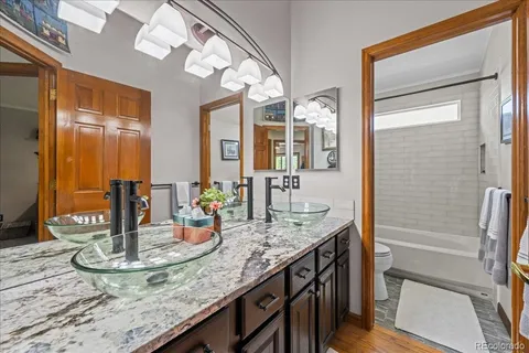 a bathroom with a granite countertop sink and a mirror