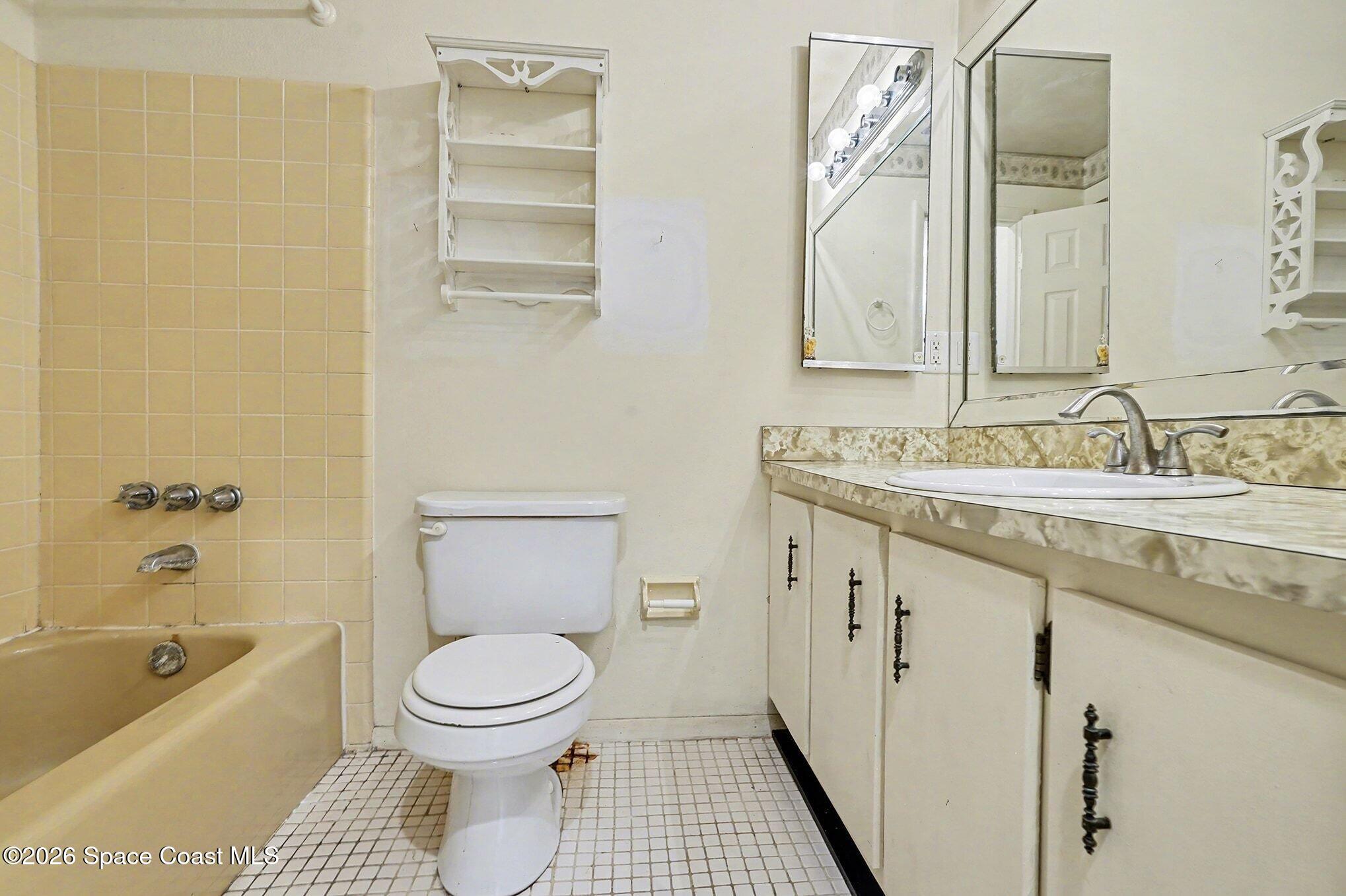 3205 Dade Circle Northeast Palm Bay, FL 32905 - Photo 18 of 35 a bathroom with a granite countertop sink a toilet and bathtub