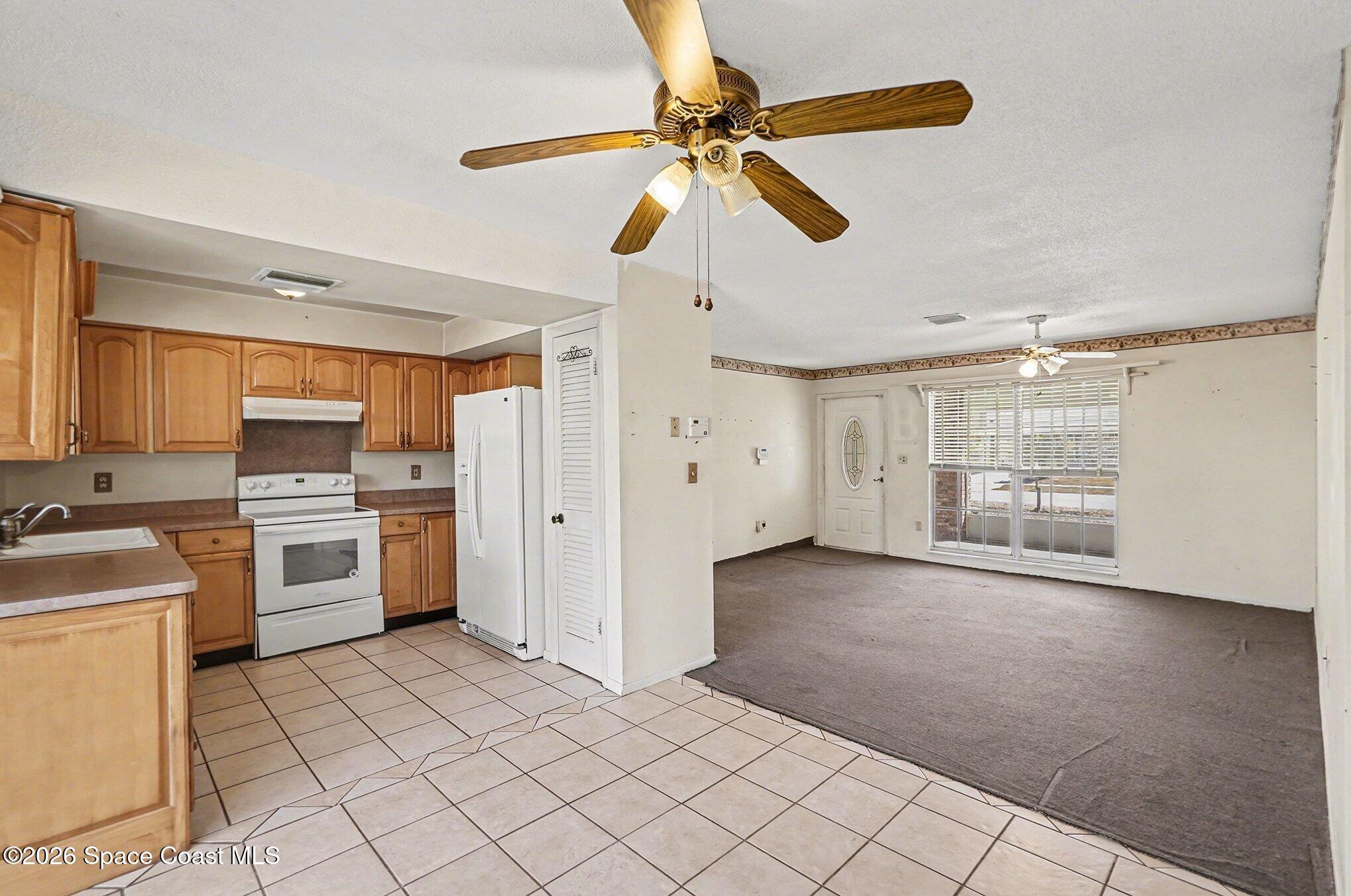 3205 Dade Circle Northeast Palm Bay, FL 32905 - Photo 3 of 35 a kitchen with a stove a sink and a refrigerator