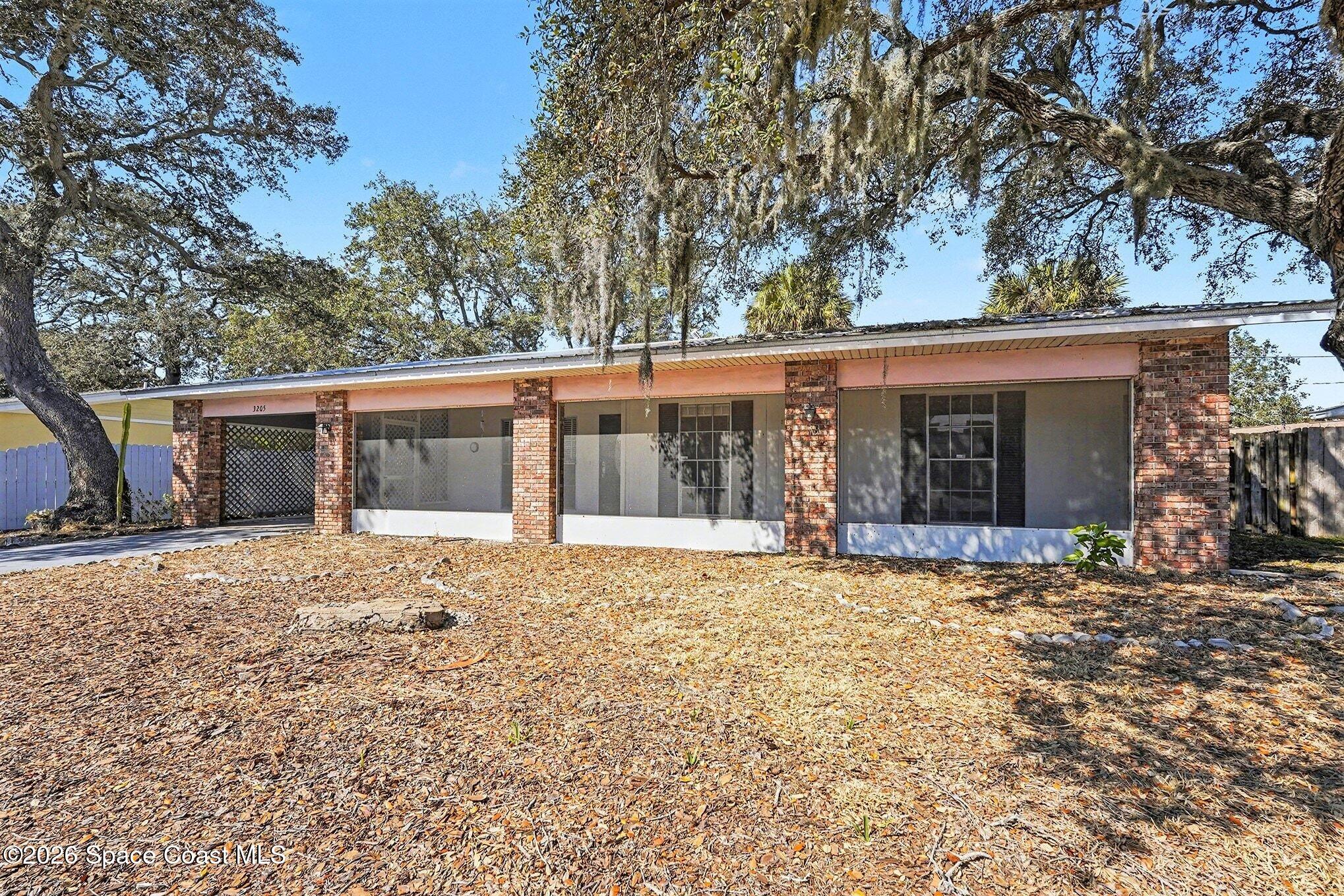 3205 Dade Circle Northeast Palm Bay, FL 32905 - Photo 6 of 35 front view of a house with a large window and a large tree
