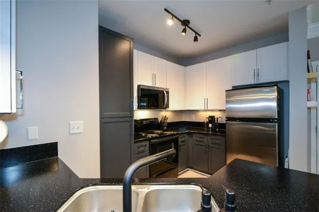 a kitchen with a refrigerator a sink a stove and cabinets