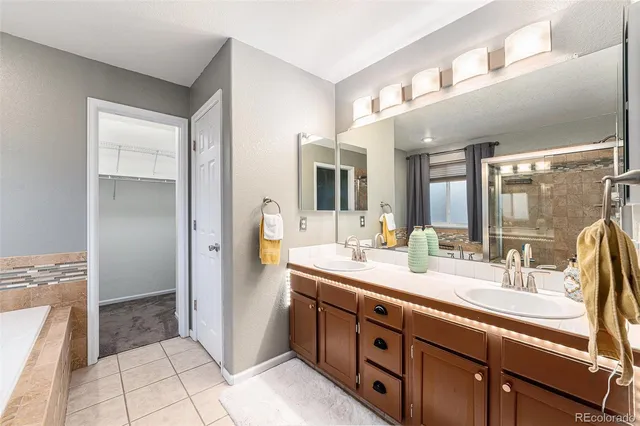 a spacious bathroom with a double vanity sink a mirror and a shower