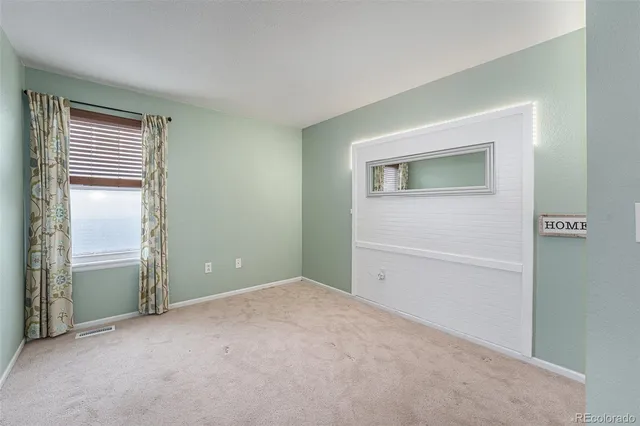 a view of an empty room with closet and a window