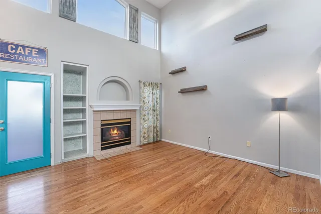 a view of empty room with wooden floor and fireplace