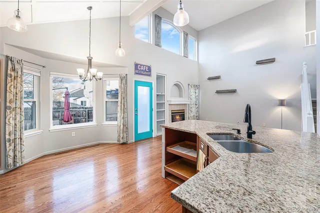 a kitchen with granite countertop a sink cabinets and wooden floor